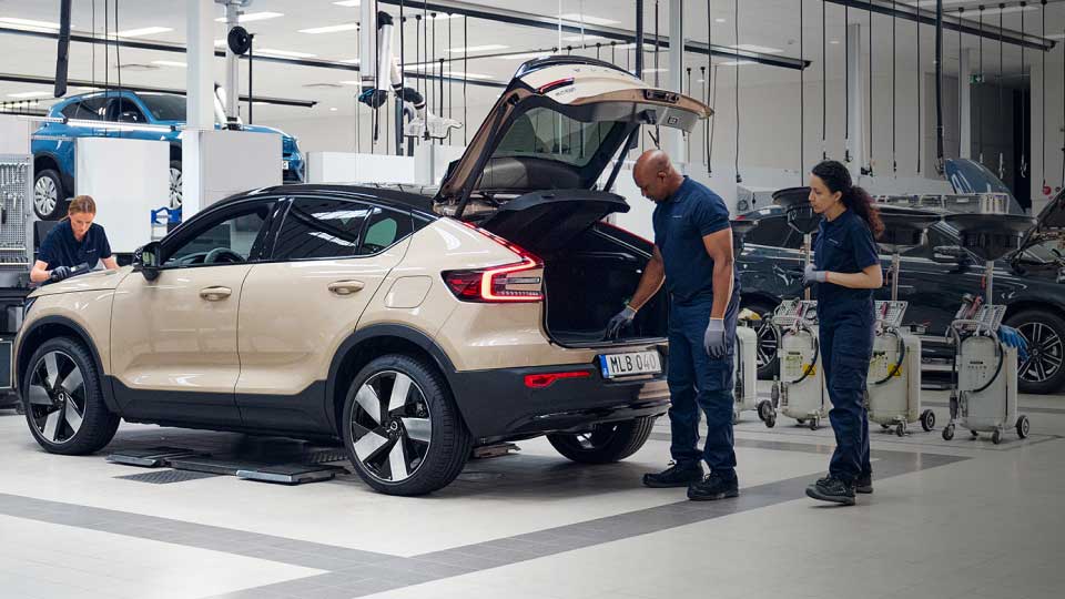 Volvos in a garage being serviced by mechanics