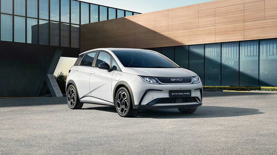White BYD Dolphin parked outside of modern office building