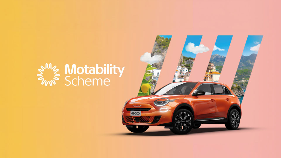 Front angled view of Fiat 600 with Italian riviera scenery in the background masked by Fiat 5 bar logo