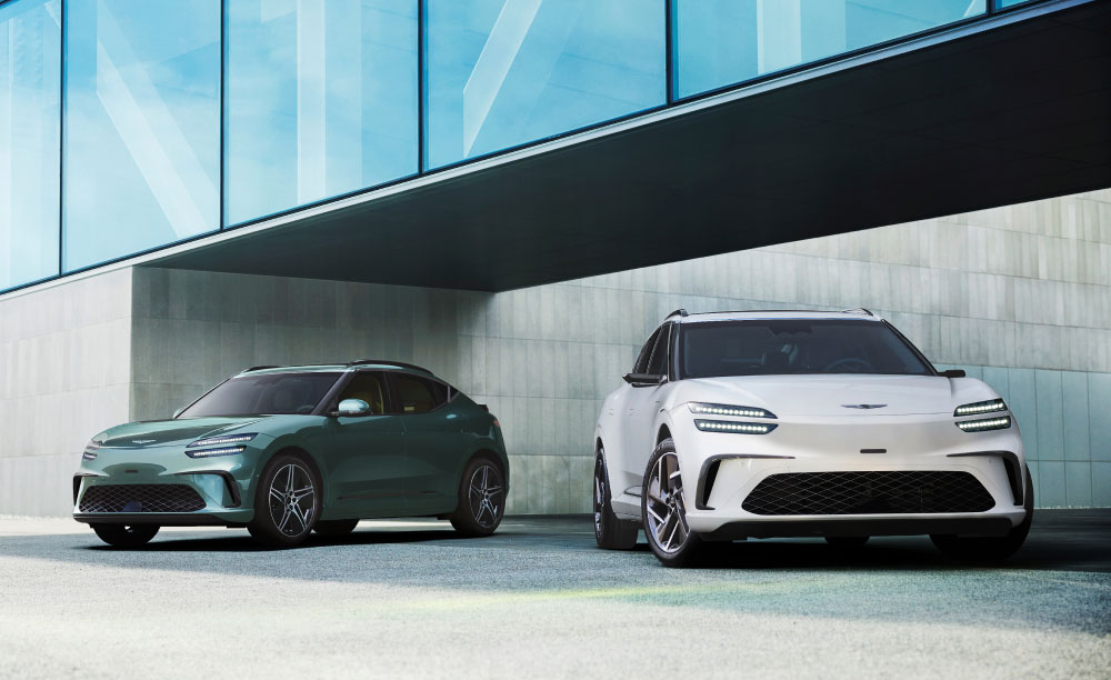 Multiple Genesis cars parked outside modern building