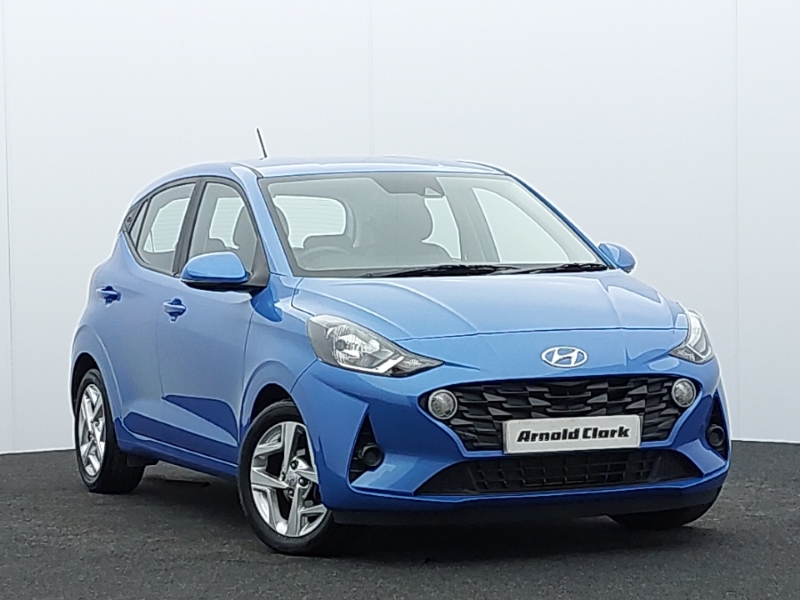 Blue Hyundai i10 parked from the front. It sits in front of an off-white background