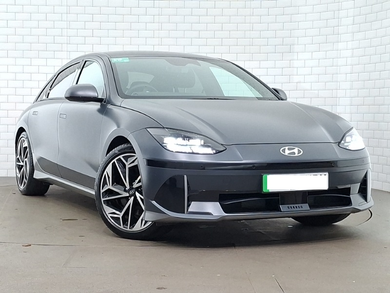 Grey Hyundai IONIQ 6 in front of white brick background